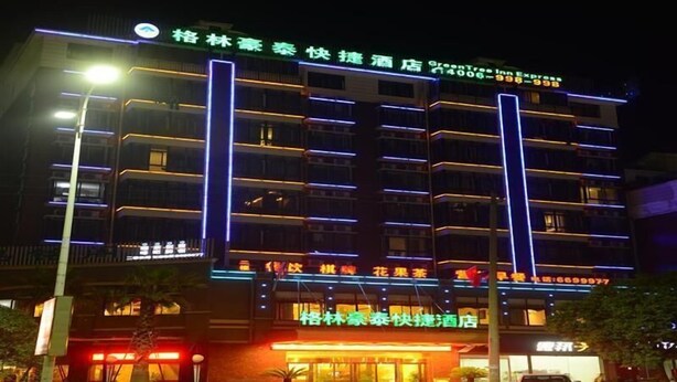A multi-story hotel with illuminated signage and a well-lit entrance. - Greentree Inn Yingtan Bus Station Express Hotel (Yingtan)