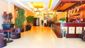 A hotel lobby with a reception desk, seating area, and decorative plants. - Greentree Inn Yingtan Bus Station Express Hotel (Yingtan)