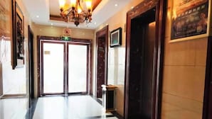 A hotel lobby with a chandelier, double doors, a small table, and a sign on the wall. - Greentree Inn Yingtan Bus Station Express Hotel (Yingtan)