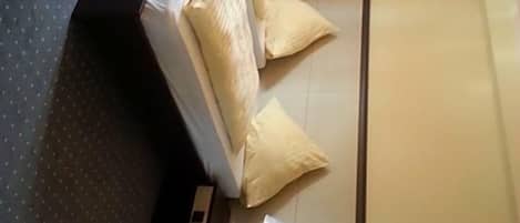 Una habitación de hotel con cama, mesita de noche, espejo y ventana.