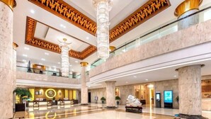 A spacious lobby with marble floors, large columns, and a reception desk. - Royal Plaza Hotel (Quzhou)