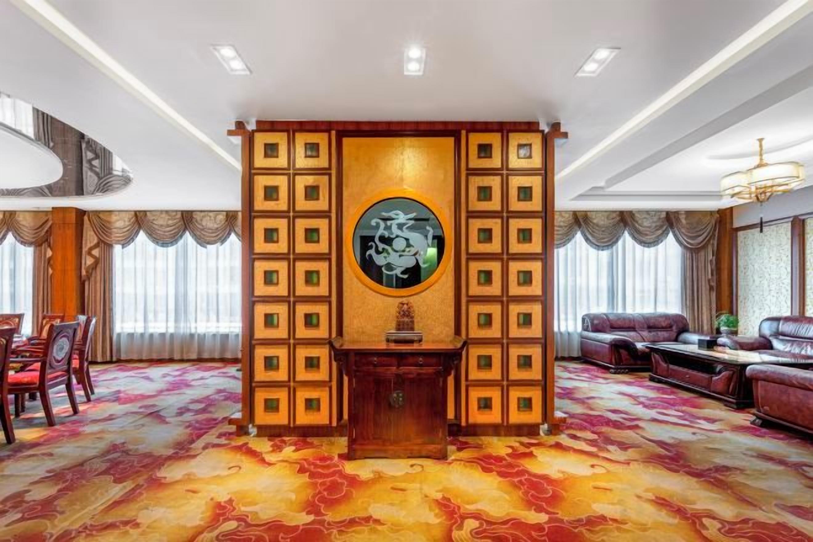 Una habitación con alfombra estampada, un panel decorativo central y disposición de asientos.