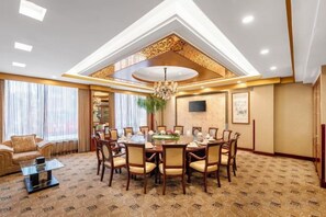 A hotel dining room with a round table, chairs, and a chandelier. - Royal Plaza Hotel (Quzhou)