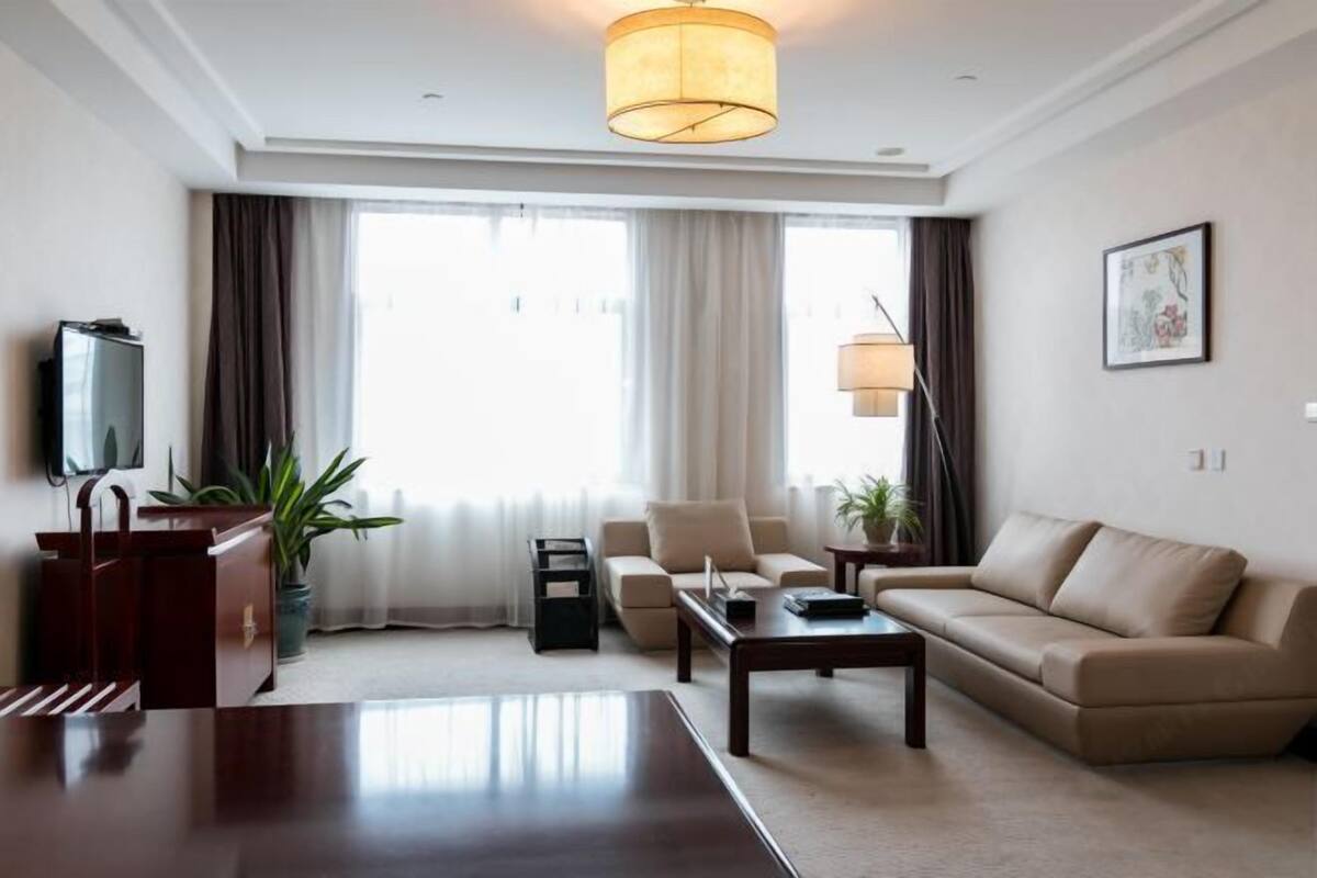 A modern living room with a sofa, coffee table, and TV.