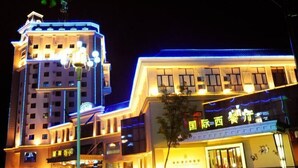 Un hotel con varios pisos, señalización iluminada y una entrada destacada.