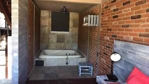 Une salle de bain avec une baignoire, une douche et un petit tabouret.