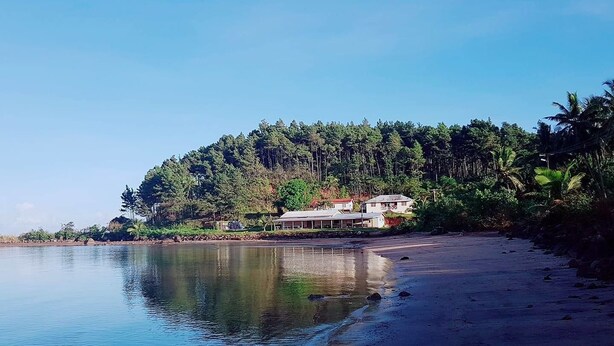 A beachfront property with a house and a large body of water. - Navutovuto Accommodation (Kadavu Island)