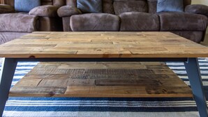 A wooden coffee table with a striped rug in front of a brown leather sofa. - Candlelight - Airlie Beach (Airlie Beach)