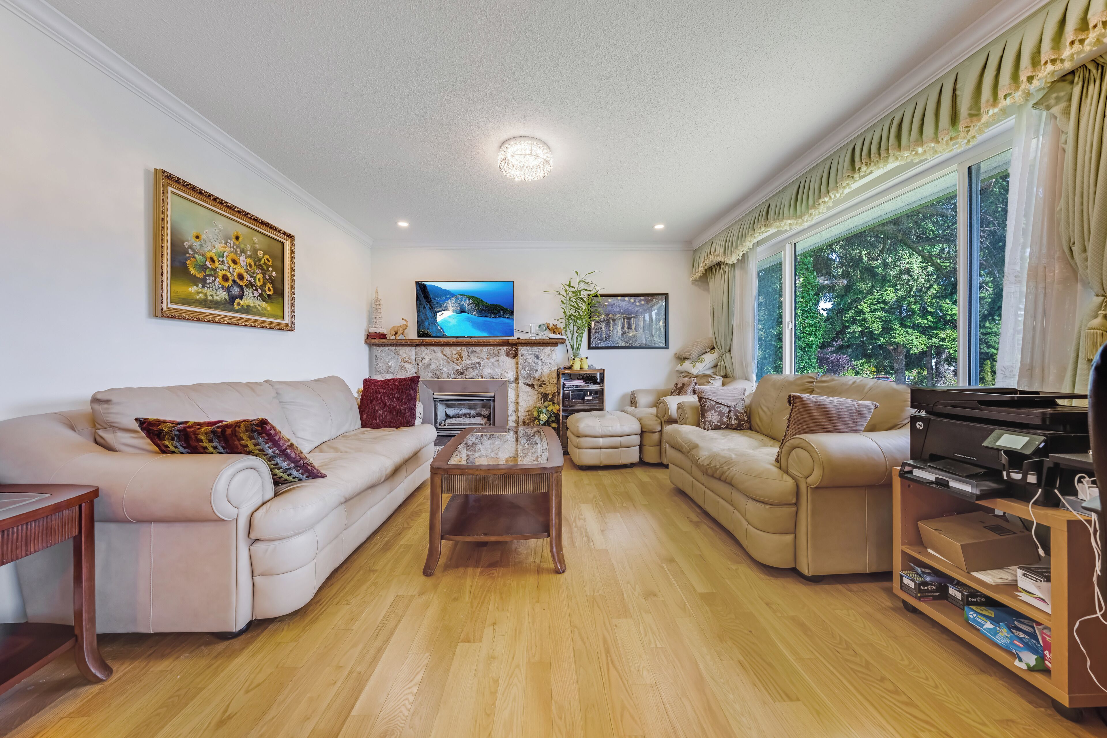 A living room with a sofa, armchairs, a coffee table, a television, and a piano.