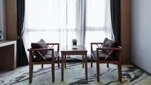 A room with two wooden chairs, a small table, and a potted plant. - Guiyang Jianghao Grand Hotel (Guiyang)