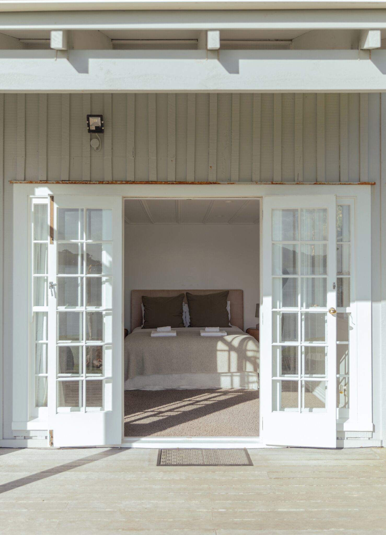 A room with a bed, a window, and a door.