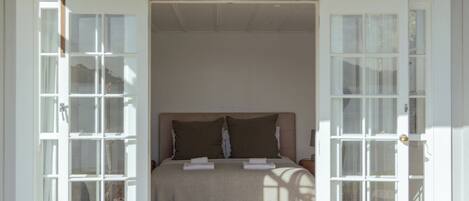 A room with a bed, a window, and a door.