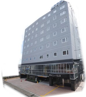 A multi-story hotel with a modern design, featuring a large glass entrance and a sign indicating it is a hotel.