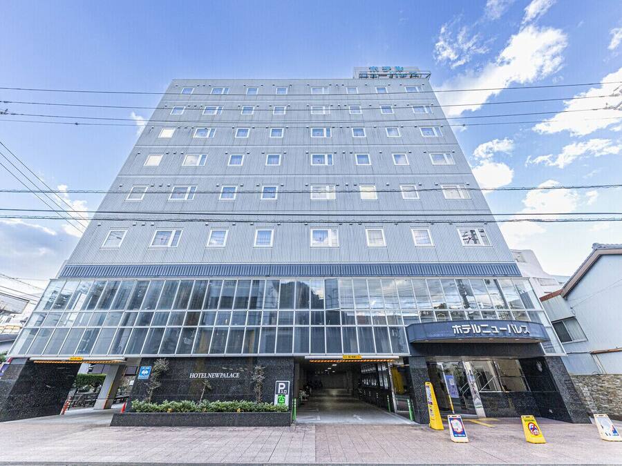 A multi-story hotel with a modern glass facade, a visible entrance, and a sign indicating it is a hotel.