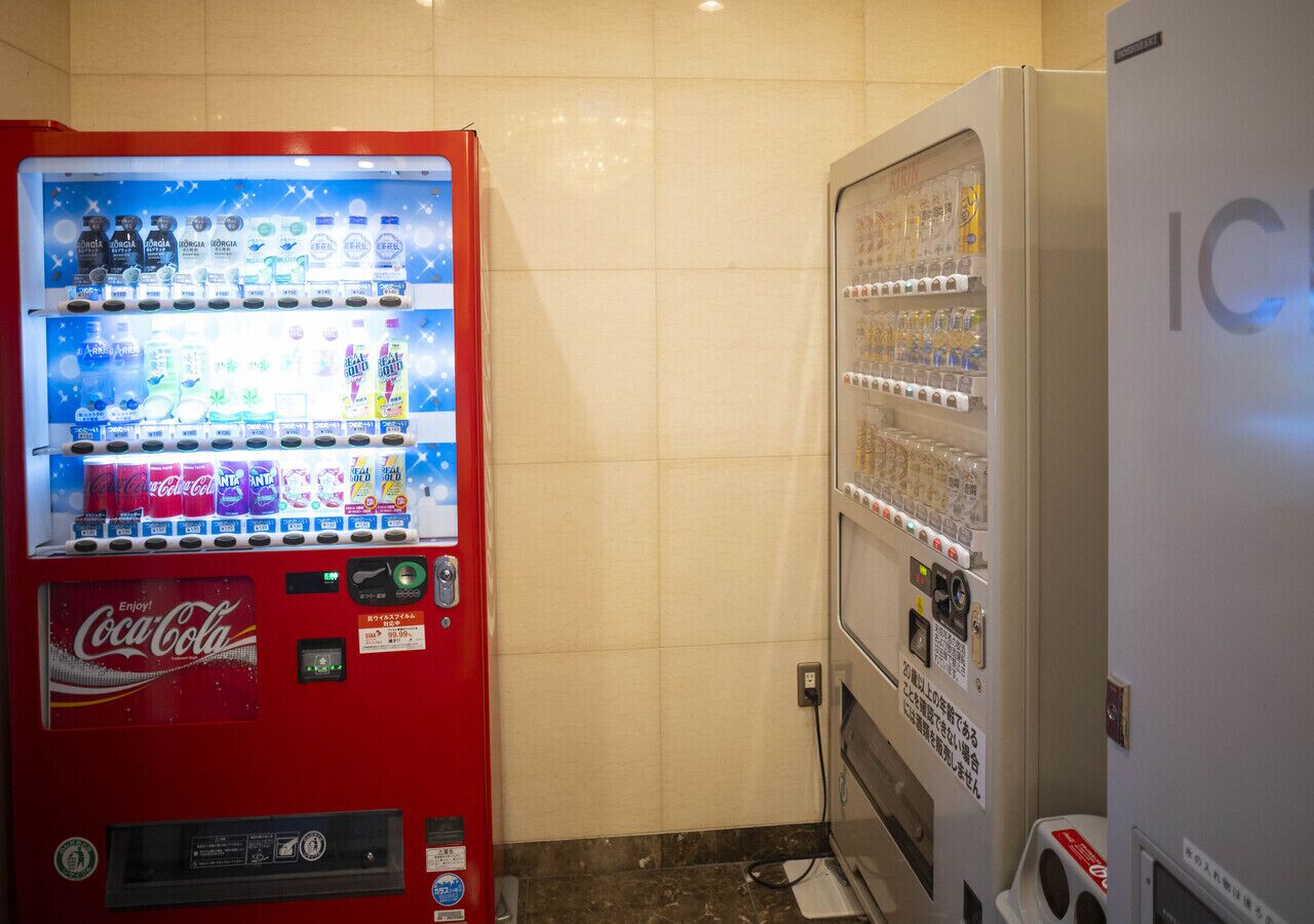 A vending machine with a Coca-Cola logo and a vending machine with a sign that says "IC".
