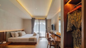 A hotel room with a bed, desk, TV, and a wardrobe. - Ubud Aura Retreat (Ubud)