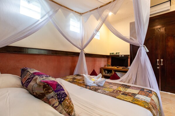 A bedroom with a bed, a TV, and a wooden cabinet. - Ubud Aura Retreat (Ubud)