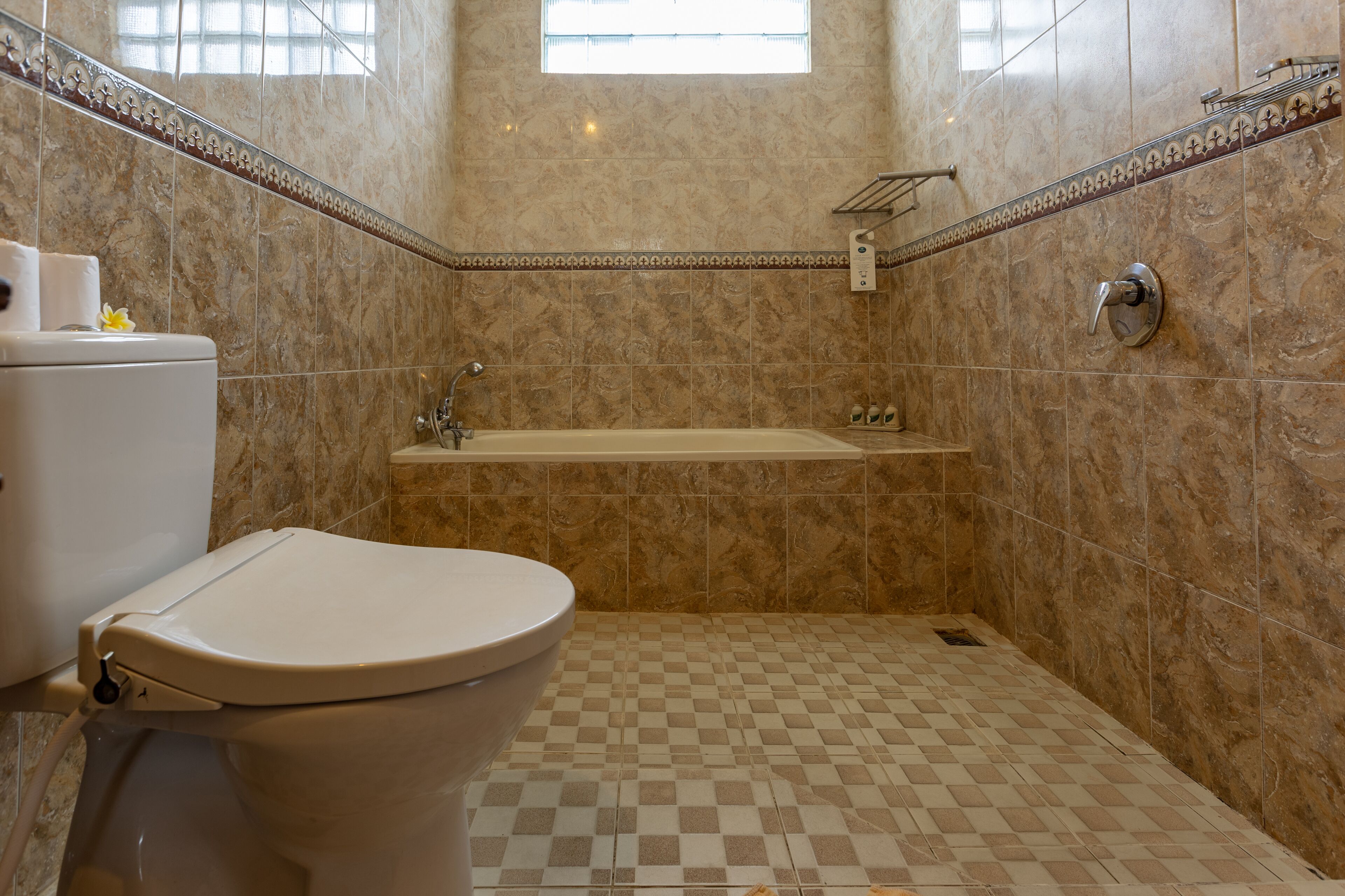 A bathroom with a toilet, a bathtub, and a shower area.
