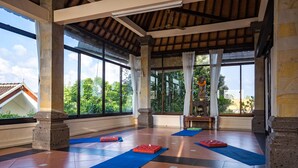 A spacious room with large windows, a tiled floor, and yoga mats. - Ubud Aura Retreat (Ubud)