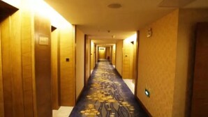 A hotel hallway with wooden walls and a carpeted floor.