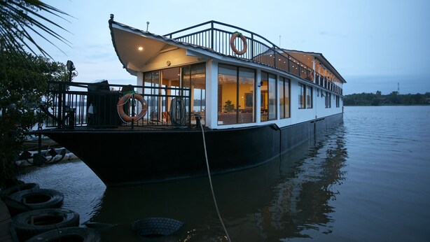A houseboat with a covered deck, large windows, and lifebuoys. - Flow by The Amber Collection - Luxury River Cruises in Sri Lanka (Piliyandala)
