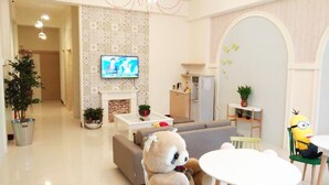 A modern living room with a sofa, a television, a fireplace, and a Minion plush toy. - Happiness 1799 (Hualien City)