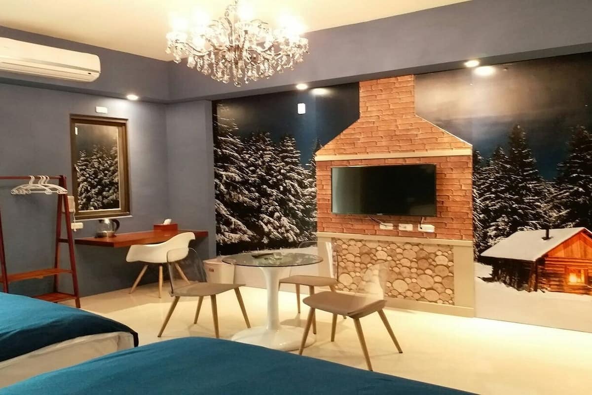 Un dormitorio con televisión, chimenea y zona de comedor.