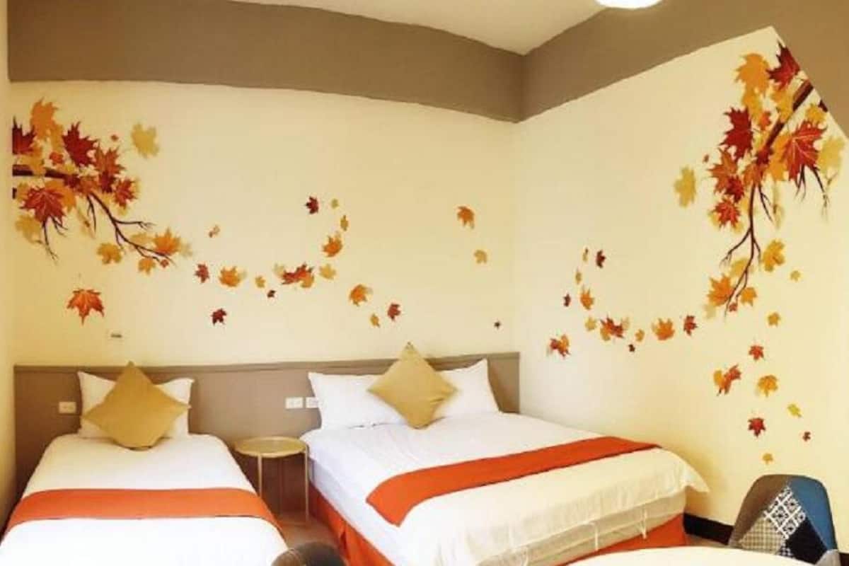 Habitación de hotel con dos camas, una mesita y una silla.