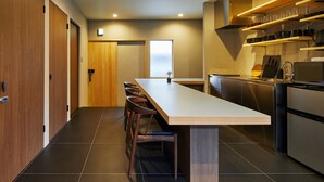 A modern kitchen with a central island, wooden cabinets, and stainless steel appliances.