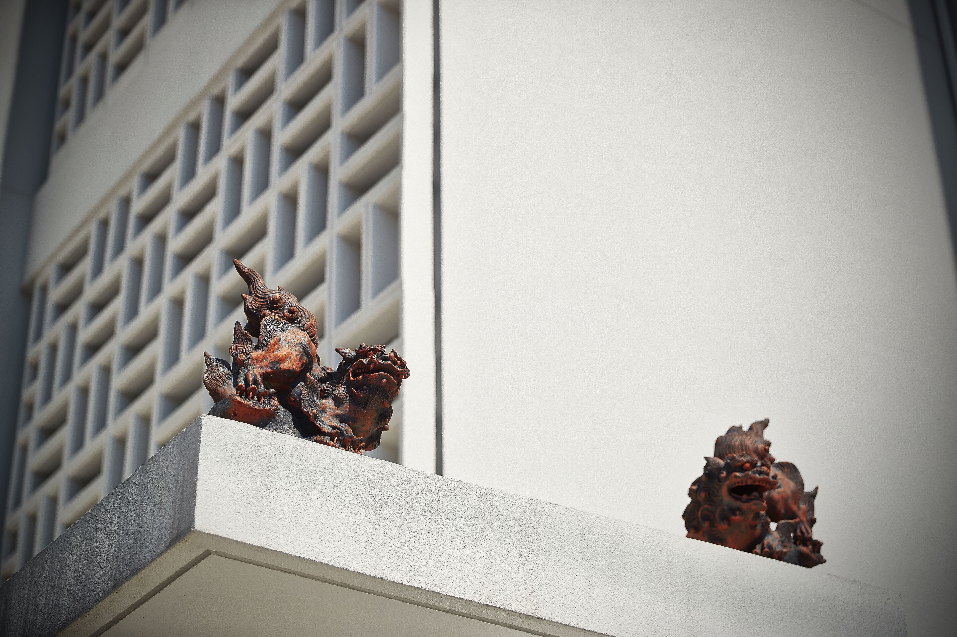 Un edificio con una estatua decorativa de un león en el tejado.