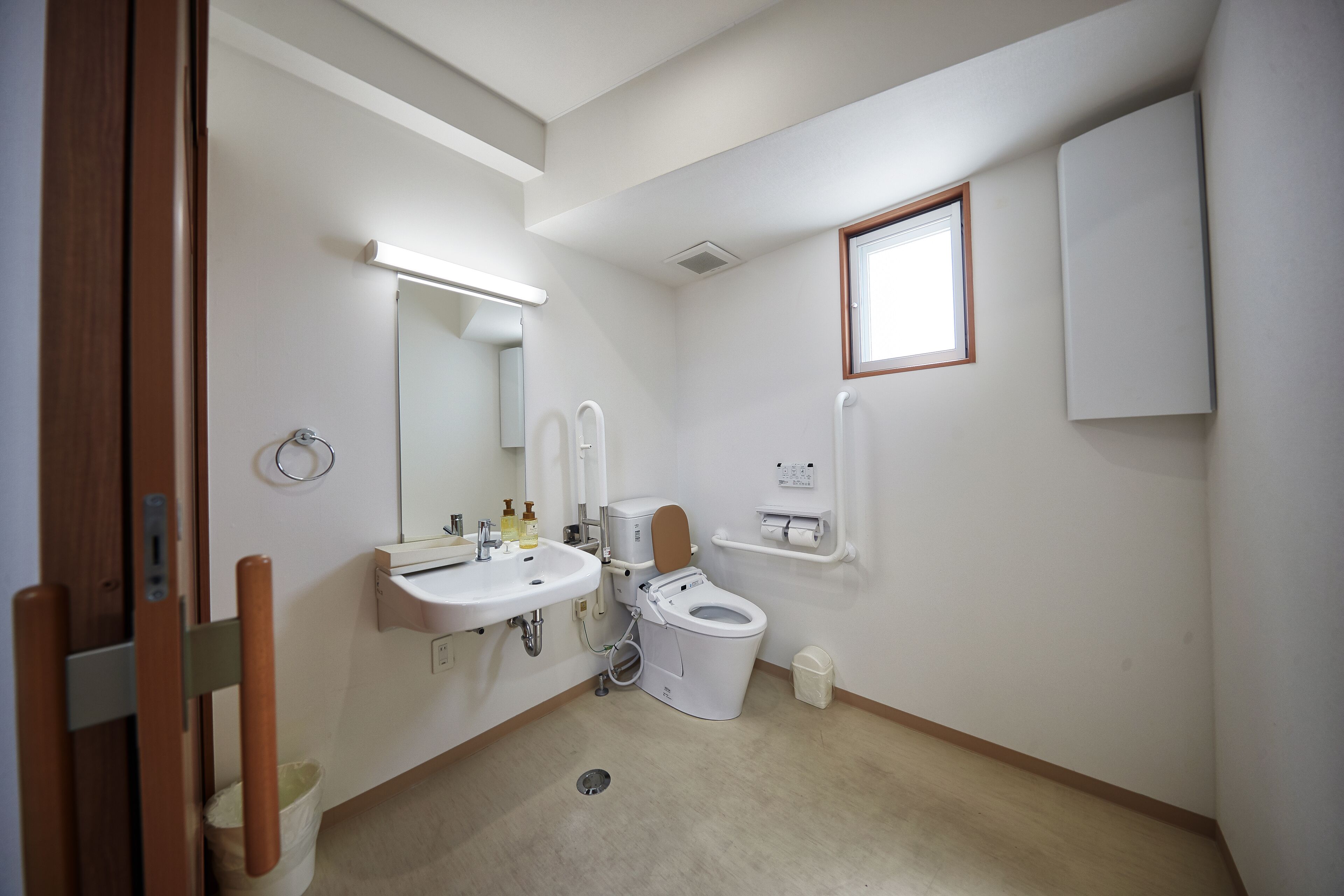 A small, clean bathroom with a toilet, sink, and mirror.