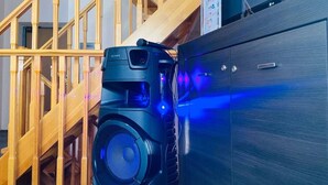 Een thuisbioscoopsysteem met een grote speaker en een flatscreen televisie op een houten kast.