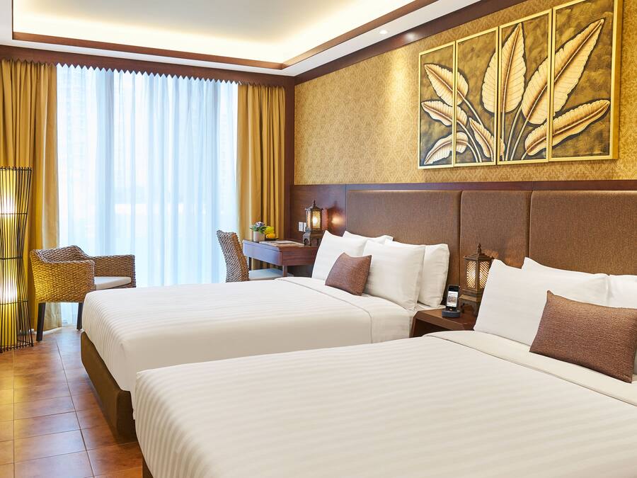 A hotel room with two beds, a desk, a chair, and a large window with curtains.