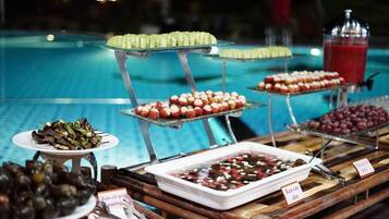 Een buffet met diverse gerechten, waaronder zeevruchten, fruit en desserts.