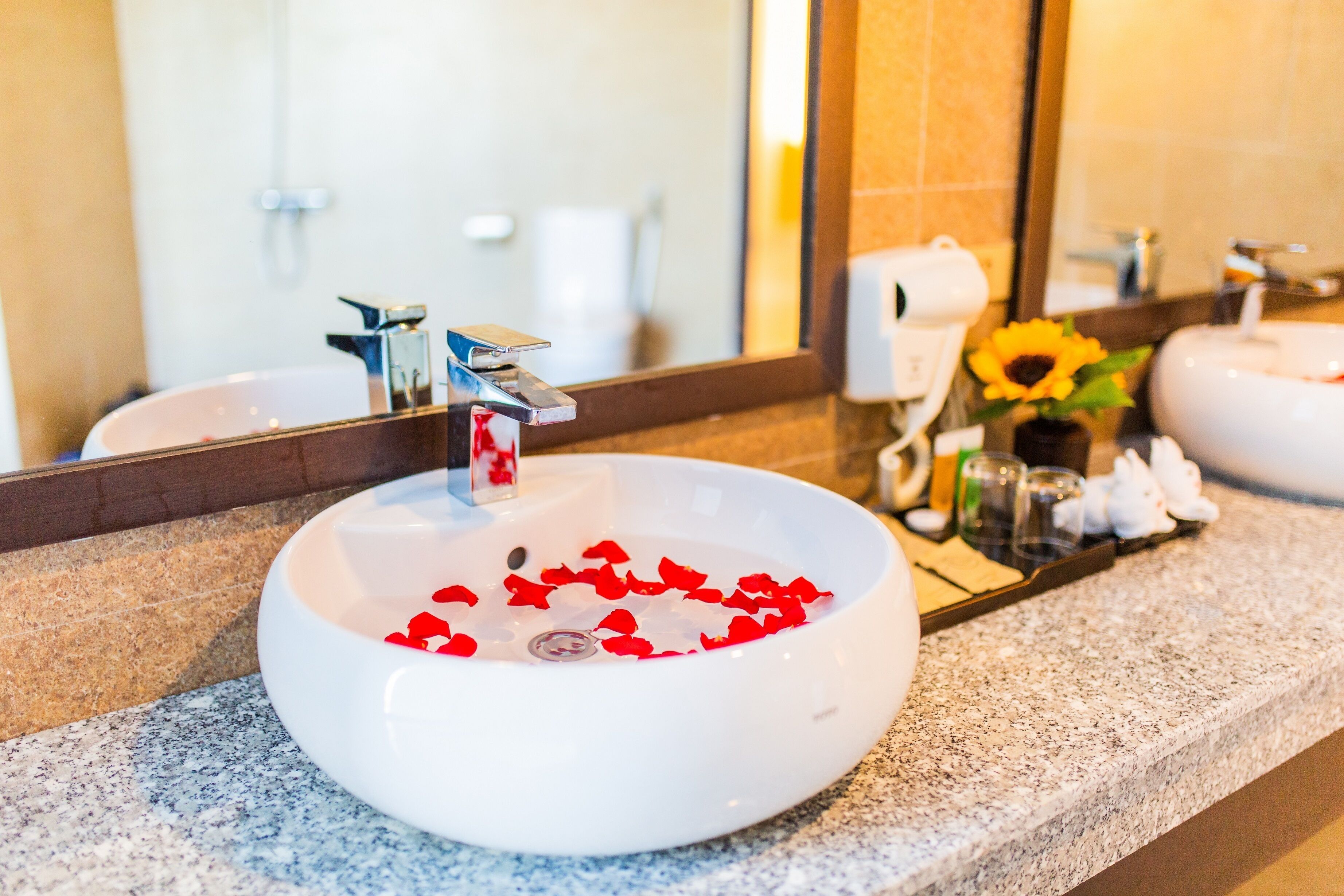 Ein Badezimmer mit weißem Waschbecken, einem Spiegel und einer Arbeitsplatte.