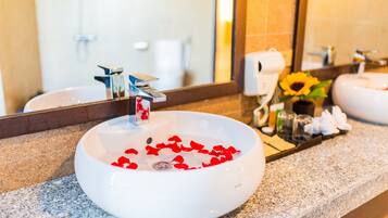 Ein Badezimmer mit weißem Waschbecken, einem Spiegel und einer Arbeitsplatte.