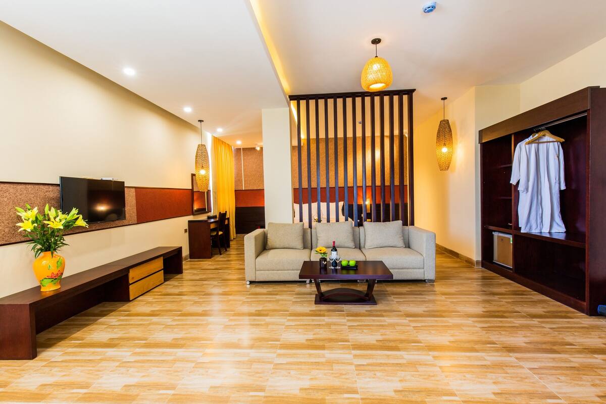 Un hall d’hôtel moderne avec un canapé, une table basse et un téléviseur fixé au mur.