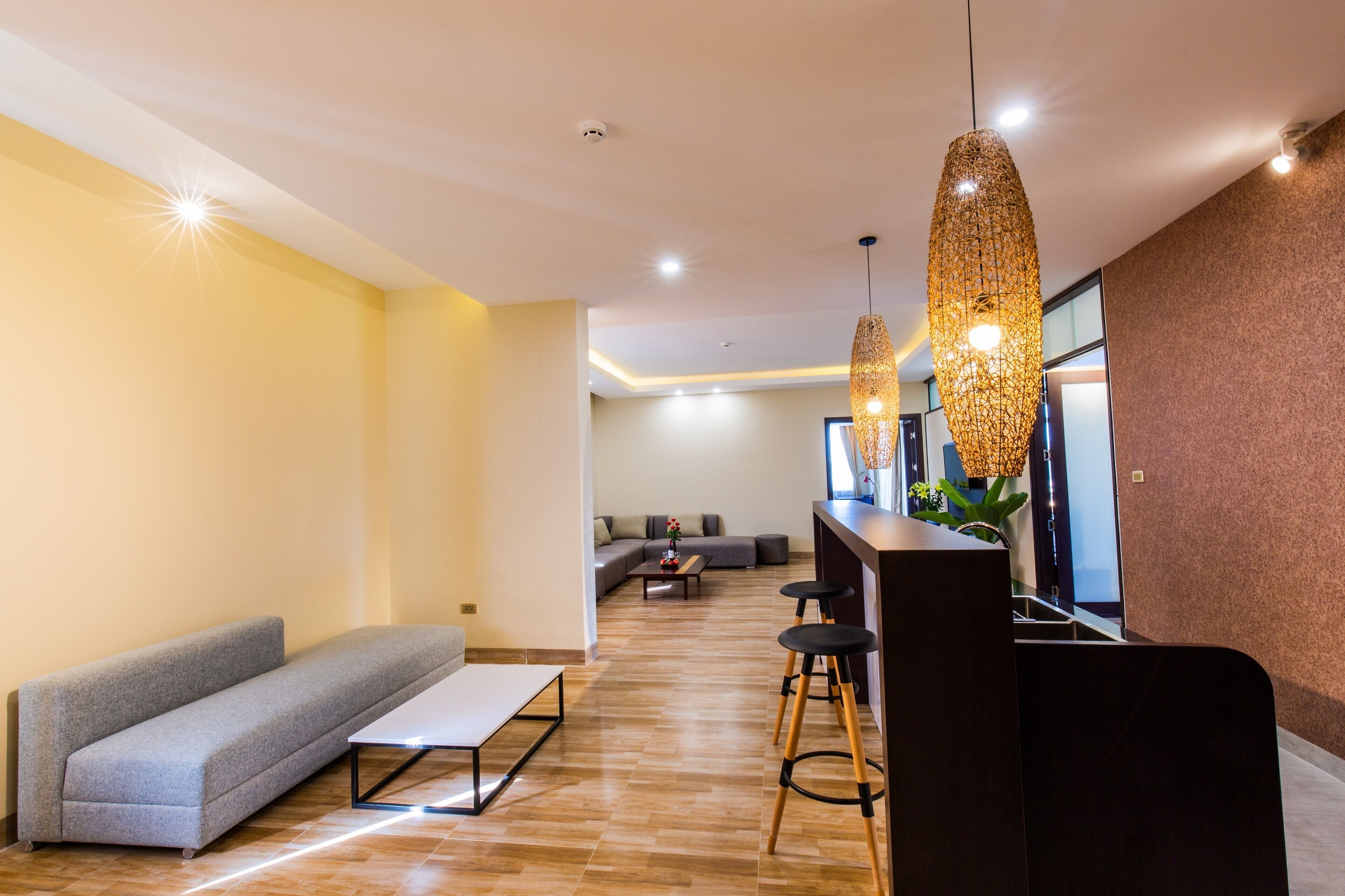 Uma sala de estar moderna com sofá, mesa de centro e um espaço bar com banquetas.