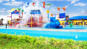 Um parque aquático com vários toboáguas e atrações aquáticas, rodeado por uma piscina e vegetação.