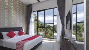 Een hotelkamer met een groot bed, een bureau en uitzicht op de omgeving.