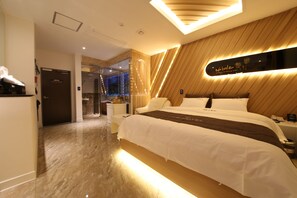 A modern hotel room with a large bed, a wooden accent wall, and a sign that reads "Noble Vintage Collection Hotel". - Noble Muintel (Suncheon)