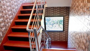 A staircase with metal railings and a tiled wall. - Hotel Kishna Palace (Dehradun)