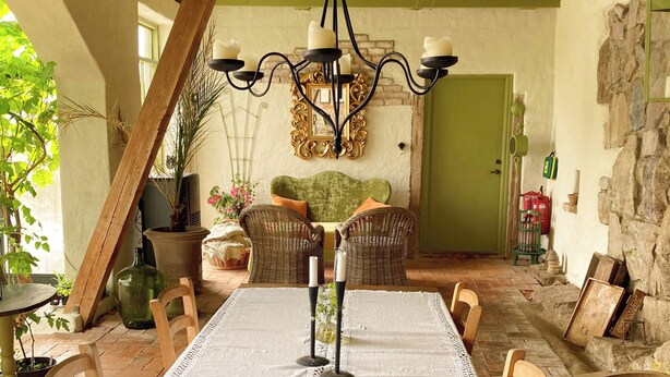 A dining area with a wooden table, chairs, and a chandelier.