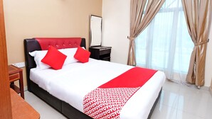 A hotel room with a bed, a nightstand, a mirror, and a window with curtains. - Hotel O Ayuni Hotel (Bandar Baru Bangi)