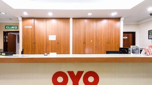 A reception desk with a wooden finish and the logo "OYO" prominently displayed. - Hotel O Ayuni Hotel (Bandar Baru Bangi)