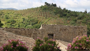A stone building with a small door, surrounded by terraced fields and greenery. - Locanda di Cadì (Petralia Soprana)