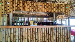 A bamboo-framed bar area with various bottles and snacks. - La Acuario Beach Inn (San Vicente)