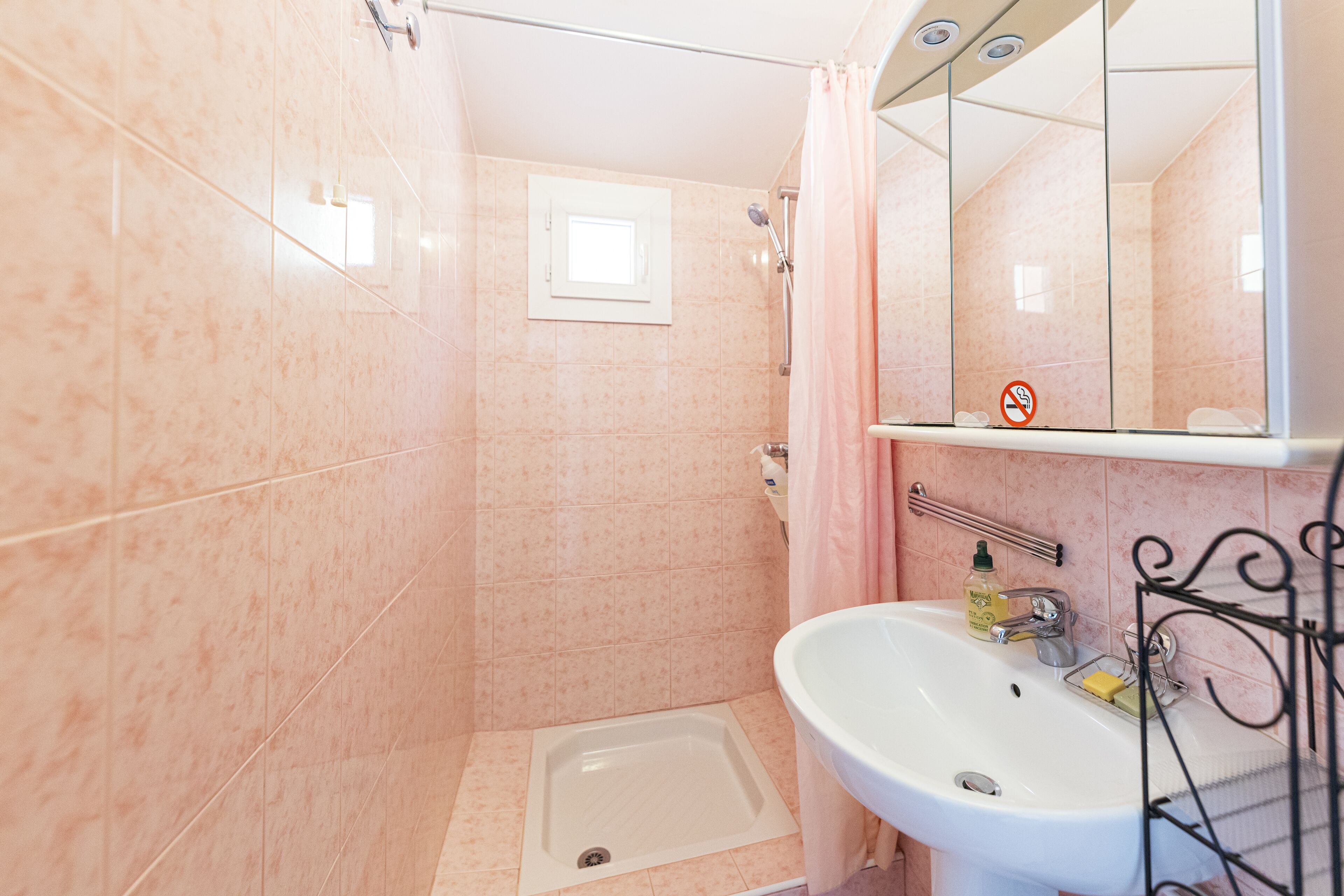 A bathroom with a shower, a sink, and a mirror.