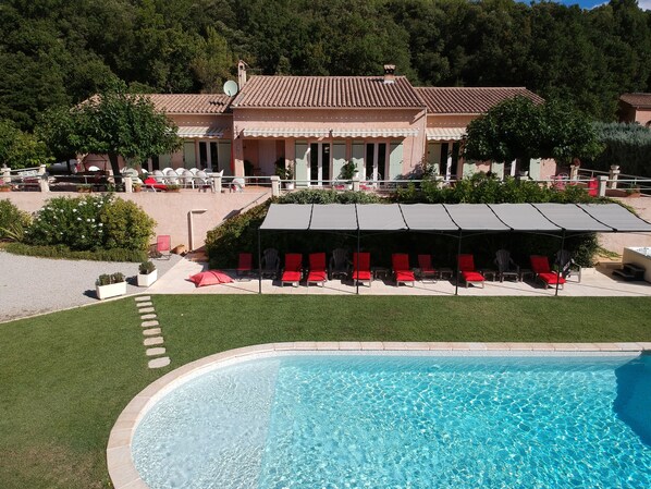 Una piscina al aire libre de temporada, sombrillas