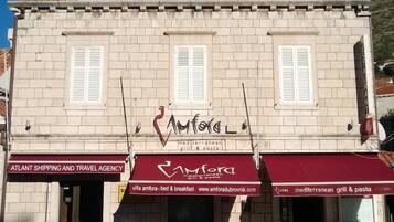 A building with a sign for 'Amfora' restaurant, featuring Mediterranean cuisine.